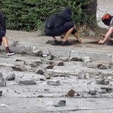 Vermummte zerschlagen Gehwegplatten. Man kann nur hoffen, dass keiner dieser Steine einen Menschen das Leben oder die Gesundheit kosten wird