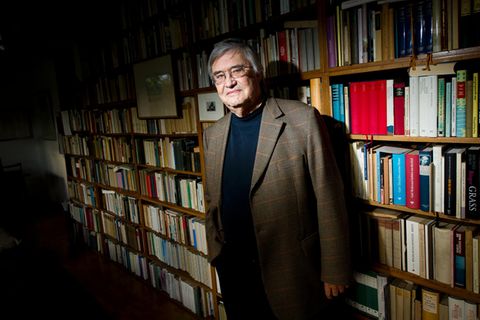 Autor Peter Härtling steht vor vollen Bücherregalen in seinem Haus in Walldorf, Hessen.
