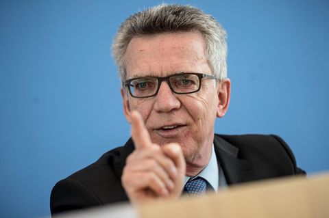 Vor blauem Hintergrund gestikuliert Bundesinnenminister Thomas de Maizière mit gestrecktem rechten Zeigefinger