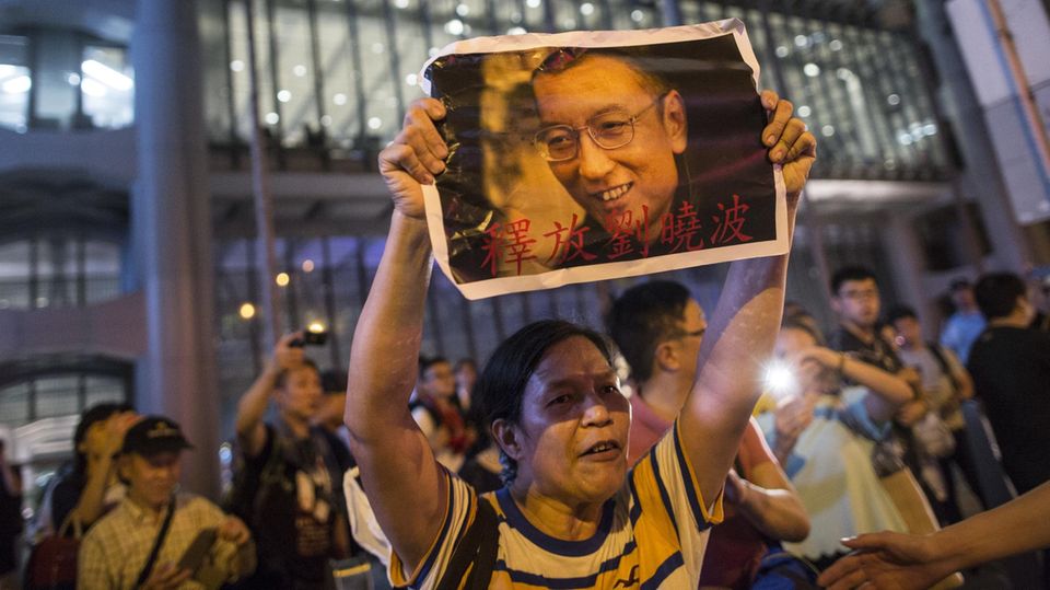 Protestierende in Hong Kong halten Bilder des verhafteten Menschenrechtsaktivisten Liu Xiaobo in die Höhe