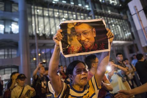 Protestierende in Hong Kong halten Bilder des verhafteten Menschenrechtsaktivisten Liu Xiaobo in die Höhe