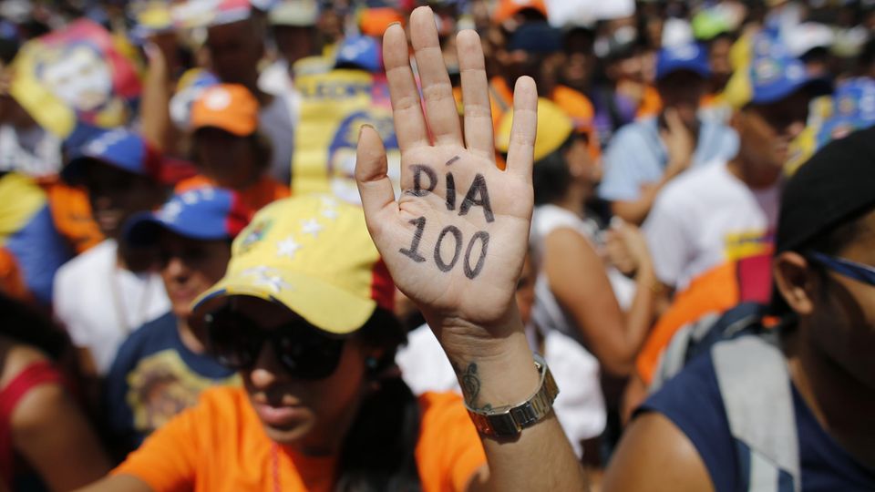 Venezuela: Eine Demonstrantin hebt ihre Hand, auf der "Tag 100" steht