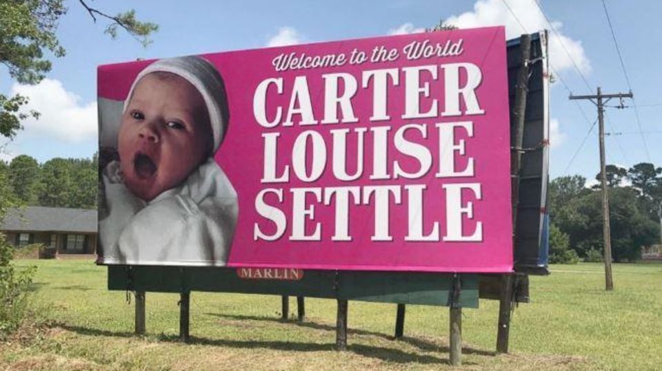 Werbeschild mit Baby und Aufschrift "Welcome to the World, Carter Louise Settle"