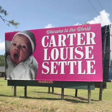 Werbeschild mit Baby und Aufschrift "Welcome to the World, Carter Louise Settle"