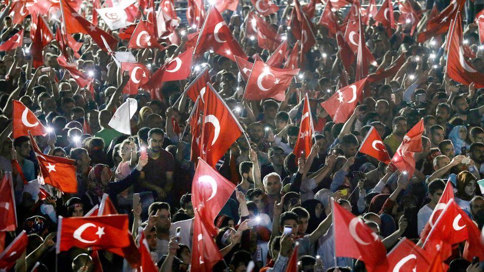 Ein Jahr nach dem Putschversuch: Teilnehmer einer Gedenkveranstaltung für die Opfer des gescheiterten Putschversuchs vor einem Jahr schwenken vor dem türkischen Parlamentsgebäude in Ankara Fahnen. Teilnehmer einer Gedenkveranstaltung für die Opfer des gescheiterten Putschversuchs vor einem Jahr schwenken vor dem türkischen Parlamentsgebäude in Ankara Fahnen.