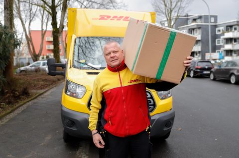 DHL-Paketbote liefert Paket aus