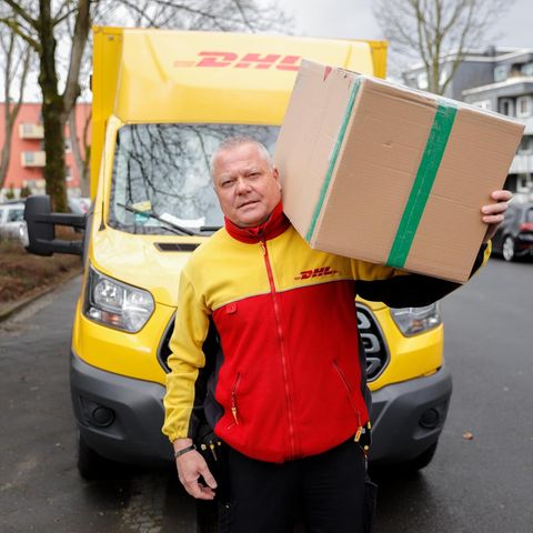 DHL-Paketbote liefert Paket aus