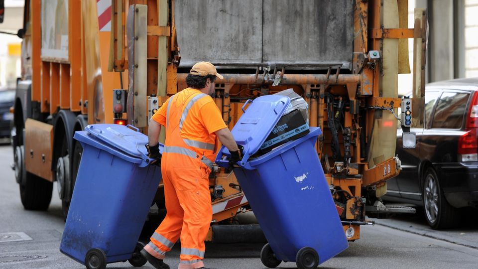 Müllabfuhr: Müllmann bringt Tonnen zum LKW Müllabfuhr: Müllmann bringt Tonnen zum LKW