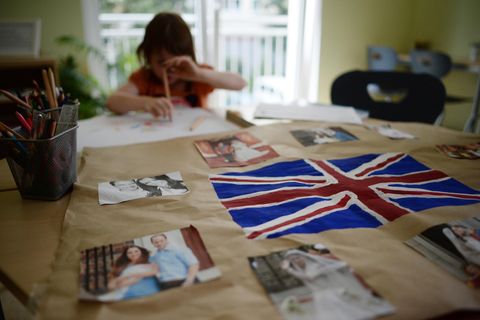 Ein kleines Mädchen sitzt am Tisch und malt. Vor ihr liegt die britische Flagge