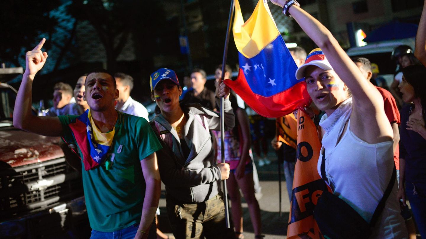 Menschen in Caracas in Venezuela auf den Straßen und protestieren mit Flaggen gegen Präsident Maduro
