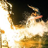 "Der Weihnachtsbaum musste entsorgt werden und so wurde er kurzerhand für ein Fotoshooting eindrucksvoll in Szene gesetzt. Hier brennt er am Ufer des Münchner Eisbachs und der Profisurfer Flori Kummer versucht alles, ihn zu löschen."