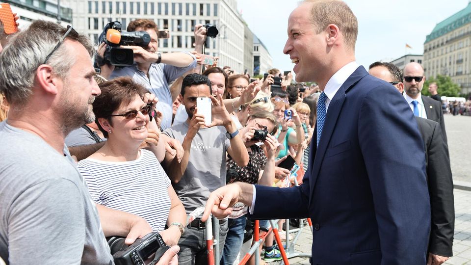 Prinz William William und Kate in Berlin: Prinz William plaudert mit einem Besucher am Brandenburger Tor