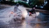 Zwei Motorradfahrer bahnen sich ihren Weg über eine überflutete Straße in der Region Hannover (Niedersachsen).