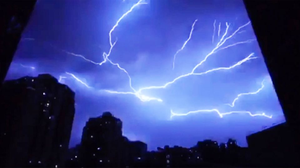 China: Gewitter liegt wie ein Spinnennetz über der Stadt