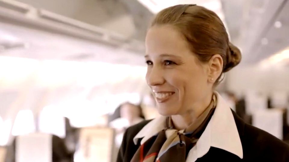 Darum verstecken Flugbegleiter beim Boarding oft eine Hand hinter ihrem Rücken Flugbegleiterin im Flugzeug