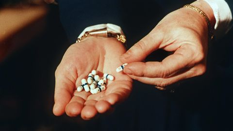 Zu sehen ist eine offene Handfläche, in der einige Tabletten liegen. Hier das HIV-Medeikament Retrovir.