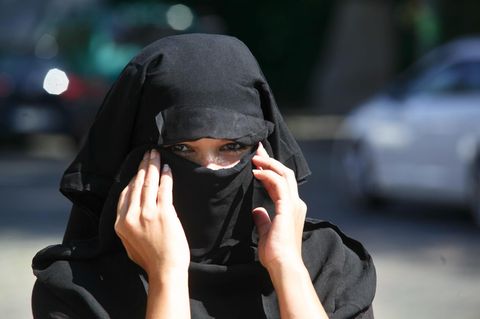 Eine junge Frau, die einen Nikab trägt, blickt in die Kamera.