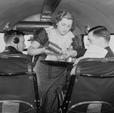 Auch ein Foto aus alten Tagen: Diese Flugbegleiterin serviert der Cockpit Crew einen Drink, als sie von Croydon, das südlich von London liegt, nach Paris fliegen.