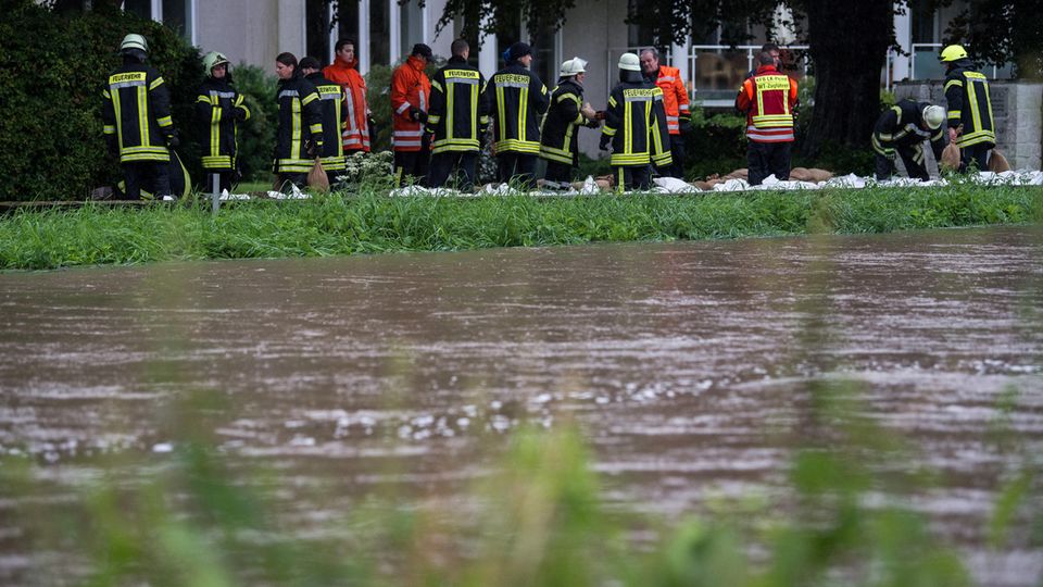 Regen ebbt ab, doch der Pegel der Innersten in Hildesheim steigt wieder an - Feuerwehrleute stabilisieren den Sandsäcke-Damm