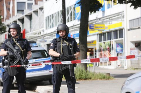Einsatzkräfte der Polizei sperren nach einer Messerattacke in einem Supermarkt in Hamburg den Tatort ab