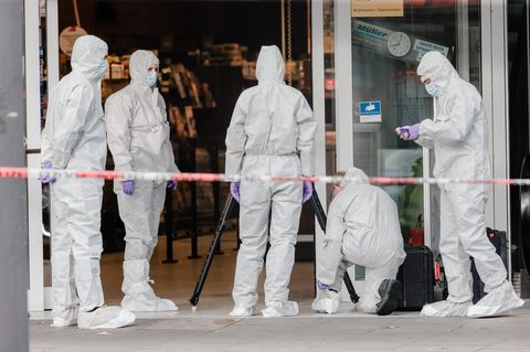 Polizisten beider Spurensicherung am Eingang des Supermarktes in Hamburg-Barmbek