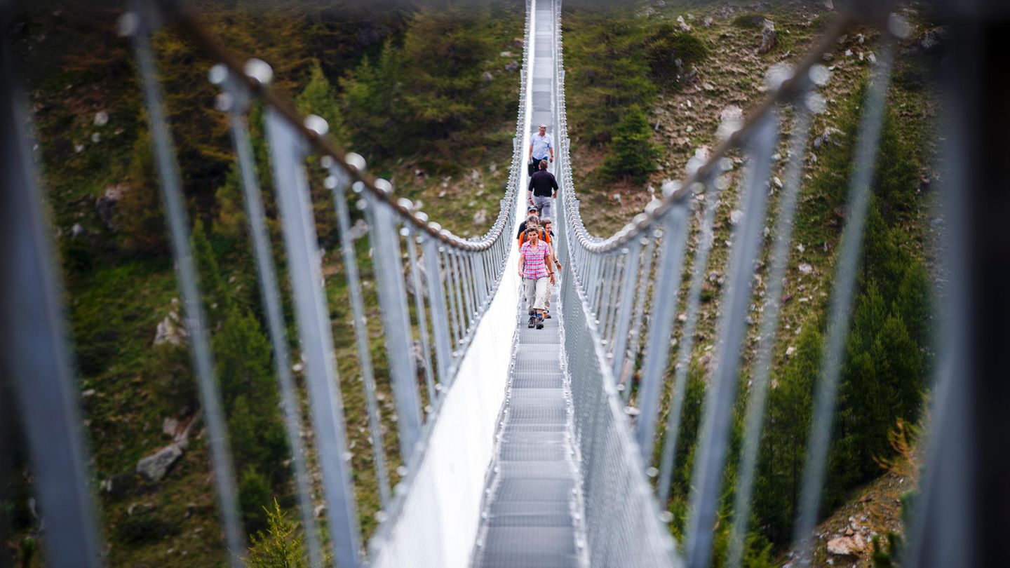 Die Wanderer schauen auf der nur 65 Zentimeter breiten Brücke bei jedem Schritt durch die Gitterroste in den 85 Meter Tiefe.