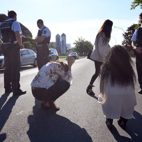 Polizisten und Zeugen stehen am vor dem Club in Konstanz, in dem die Schüsse gefallen sind