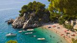 Podrače, Brela, Kroatien  Dieser winzigen Bucht an der Makarska Riviera kann man auf den Grund sehen, was Badegäste (und Boote) in einen Schwebezustand versetzt – ein absolut erstrebenswertes Feriengefühl! Die Bucht Podrače (Foto) mit ihren Kiefern und Kalksteinklippen ist eine von mehreren Strandschönheiten rund um den Ort Brela an der Küste von Dalmatien.  Info: www.brela.hr