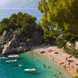 Podrače, Brela, Kroatien  Dieser winzigen Bucht an der Makarska Riviera kann man auf den Grund sehen, was Badegäste (und Boote) in einen Schwebezustand versetzt – ein absolut erstrebenswertes Feriengefühl! Die Bucht Podrače (Foto) mit ihren Kiefern und Kalksteinklippen ist eine von mehreren Strandschönheiten rund um den Ort Brela an der Küste von Dalmatien.  Info: www.brela.hr