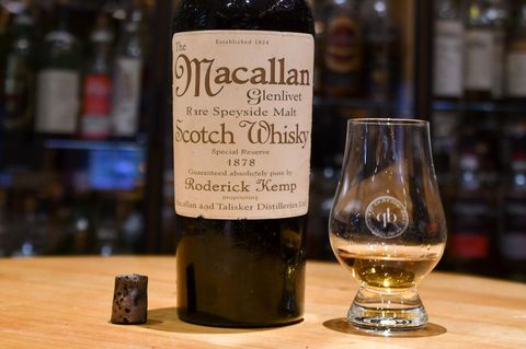 Eine Flasche Macallan Scotch Whisky von 1878 steht neben einem Whisky-Glas