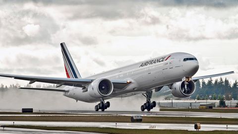 Eine Passagiermaschine von Air France landet bei wolkigem Himmel und nasser Landebahn