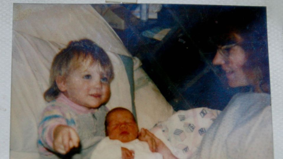 Der Junge am Tag nach seiner Geburt mit der Halbschwester und der Mutter