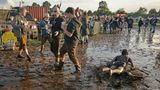 Rutschpartie: Die Fortbewegung durch die Schlammlandschaft des Festivalgeländes war für manchen Besucher am besten bäuchlings zu bewältigen