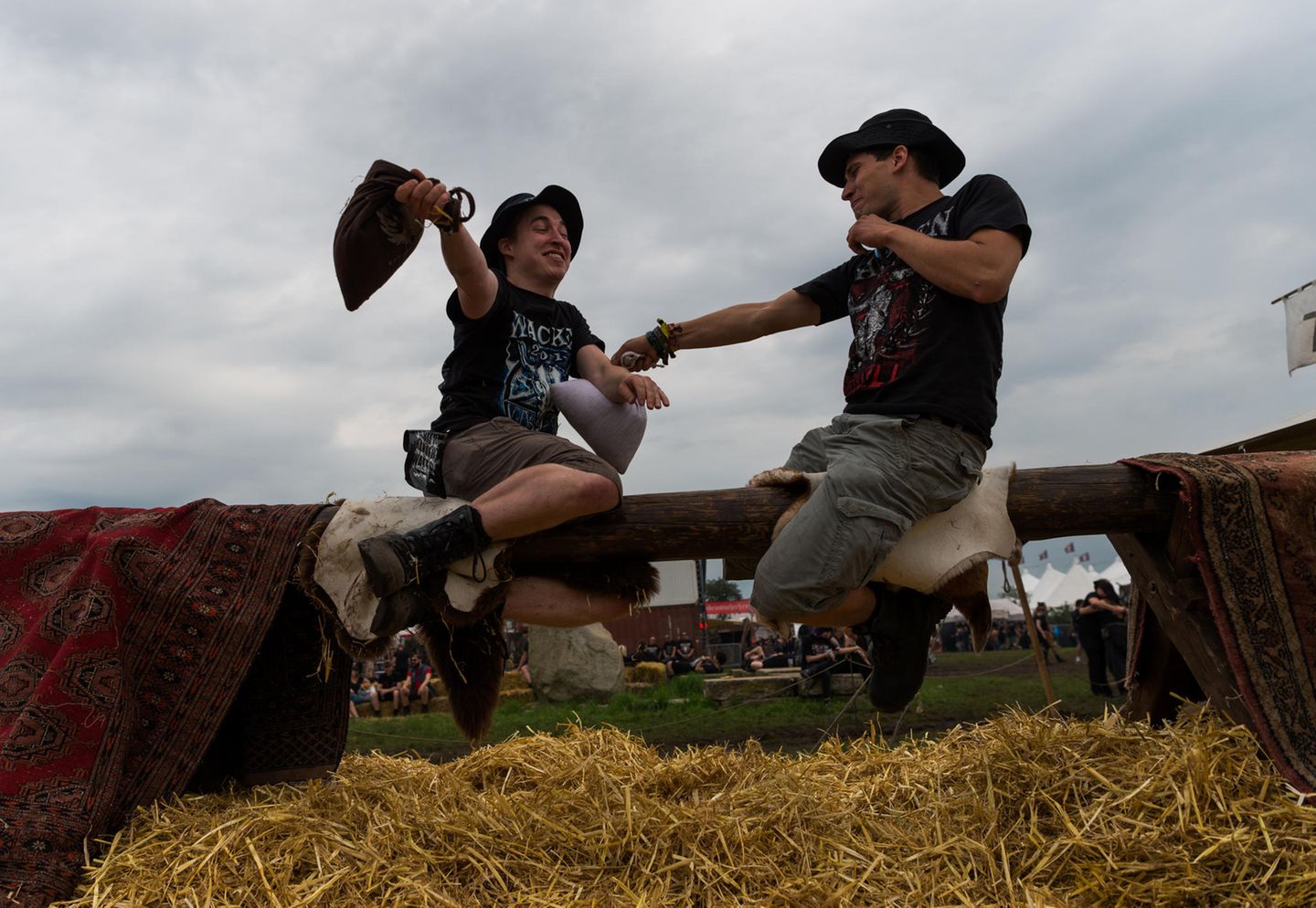 Randsportart: Zwei Besucher hauen sich mit Strohsäcken, während sie auf einem Balken sitzen. Das Spiel ist aus dem Mittelalter bekannt als "Tjost".