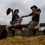 Randsportart: Zwei Besucher hauen sich mit Strohsäcken, während sie auf einem Balken sitzen. Das Spiel ist aus dem Mittelalter bekannt als "Tjost".