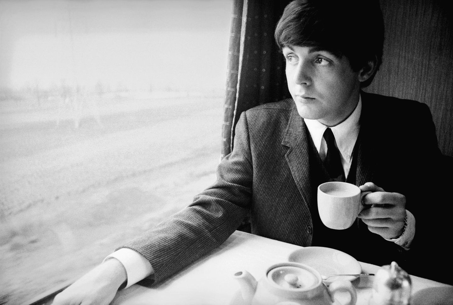 Beatlemania: Auf dem Höhepunkt der Beatlemania drehten die vier Musiker 1964 zusammen mit Regisseur Richard Lester den Film "A Hard Day's Night". Der zeigt eine Band, die von ihren Fans verfolgt und belagert wird. Das Foto entstand im Rahmen der Dreharbeiten zu diesem Film. Paul genießt auf einer Zugfahrt eine Tasse Tee. Auf dem Höhepunkt der Beatlemania drehten die vier Musiker 1964 zusammen mit Regisseur Richard Lester den Film "A Hard Day's Night". Der zeigt eine Band, die von ihren Fans verfolgt und belagert wird. Das Foto entstand im Rahmen der Dreharbeiten zu diesem Film. Paul genießt auf einer Zugfahrt eine Tasse Tee.