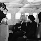 Mit im Flieger nach New York saß auch John Lennons damalige Frau Cynthia. Der Beatle fotografiert sie neben George Harrison sitzend.