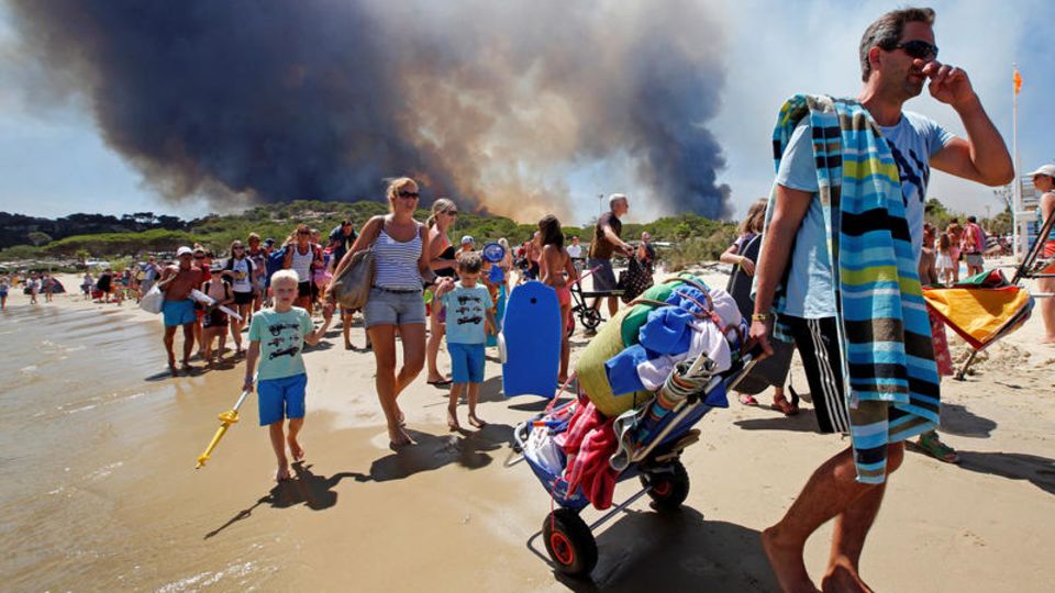 Bormes-les-Mimosas, Département Var, Frankreich: Touristen fliehen über den Strand vor den nahenden Flammen