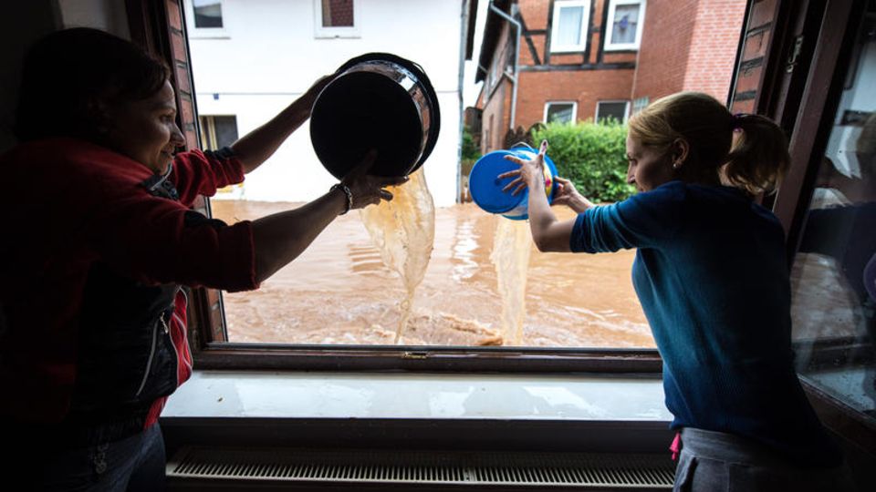 stern-Reportage: Rhüden, Harz, Niedersachsen: Mit Eimern schöpfen Frauen das Wasser aus ihrer Wohnung. 200 Häuser sind hier von den Überschwemmungen betroffen Rhüden, Harz, Niedersachsen: Mit Eimern schöpfen Frauen das Wasser aus ihrer Wohnung. 200 Häuser sind hier von den Überschwemmungen betroffen