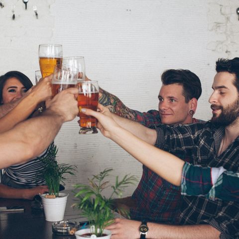 Junge Menschen stoßen mit Bier an