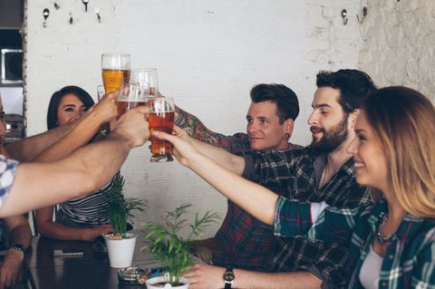 Junge Menschen stoßen mit Bier an