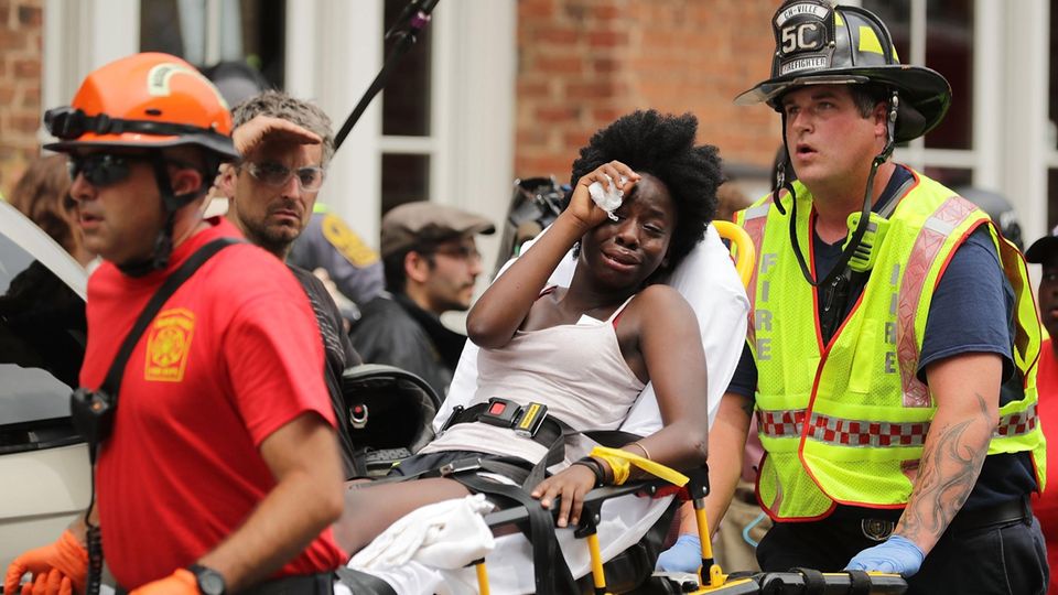 Charlottesville Auto Verletzte Helfer transportieren eine Frau ab, die verletzt wurde, als ein Auto in Charlottesville in eine Menschenmenge fuhr