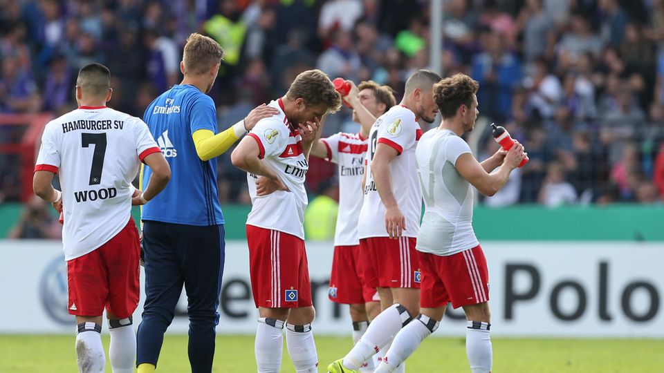Spieler des Hamburger SV stehen nach dem Erstrunden-Aus im DFB-Pokal gegen den VfL Osnbrück mit gesenkten Köpfen auf dem Rasen
