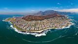 Aus der Möwenperspektive: Die Ausläufer von Kapstadt mit dem braunen Signal Hill in Bildmitte. Ganz links ist das Fußballstadion der Weltmeisterschaft von 2010 zu sehen.