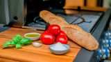 Was Sie für Bruschetta vom Grill brauchen? Ein Ciabatta oder Baguette, Fleischtomaten, eine Knoblauchzehe, Basilikum, Olivenöl und etwas Salz. 