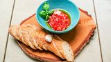 Hacken Sie die Tomaten ganz fein und geben Sie Olivenöl und Salz darüber. Schälen Sie die Knoblauchzehe und zupfen Sie sich etwas Basilikum zurecht. Das Ciabatta oder Baguette in Scheiben schneiden.