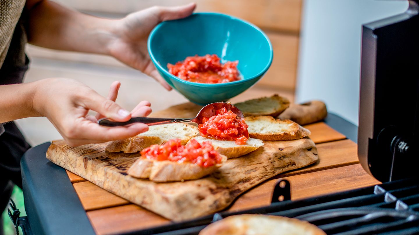 Verteilen Sie die Tomaten nun auf den Knoblauch-Brot-Hälften.