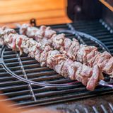 Sobald Sie alle Fleischstückchen auf Metallspieße aufgesteckt haben und der Grill heiß ist, legen Sie die Spieße darauf und machen Sie den Deckel zu.