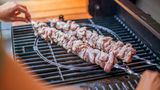 Sobald Sie alle Fleischstückchen auf Metallspieße aufgesteckt haben und der Grill heiß ist, legen Sie die Spieße darauf und machen Sie den Deckel zu.