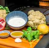 Was Sie für den orientalischen Blumenkohl brauchen? Blumenkohl, Joghurt, Granatapfel, Ras-El-Hanout, Minze, Zitrone, Knoblauch und Olivenöl.